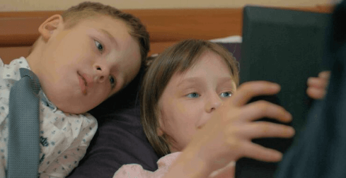 two kids watching phones